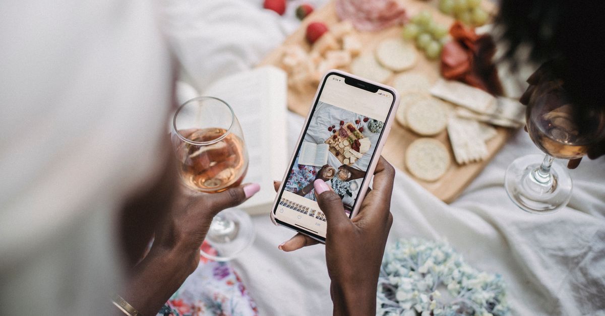 Diners photographing shared plates — the kind of scene that performs in restaurant social ads