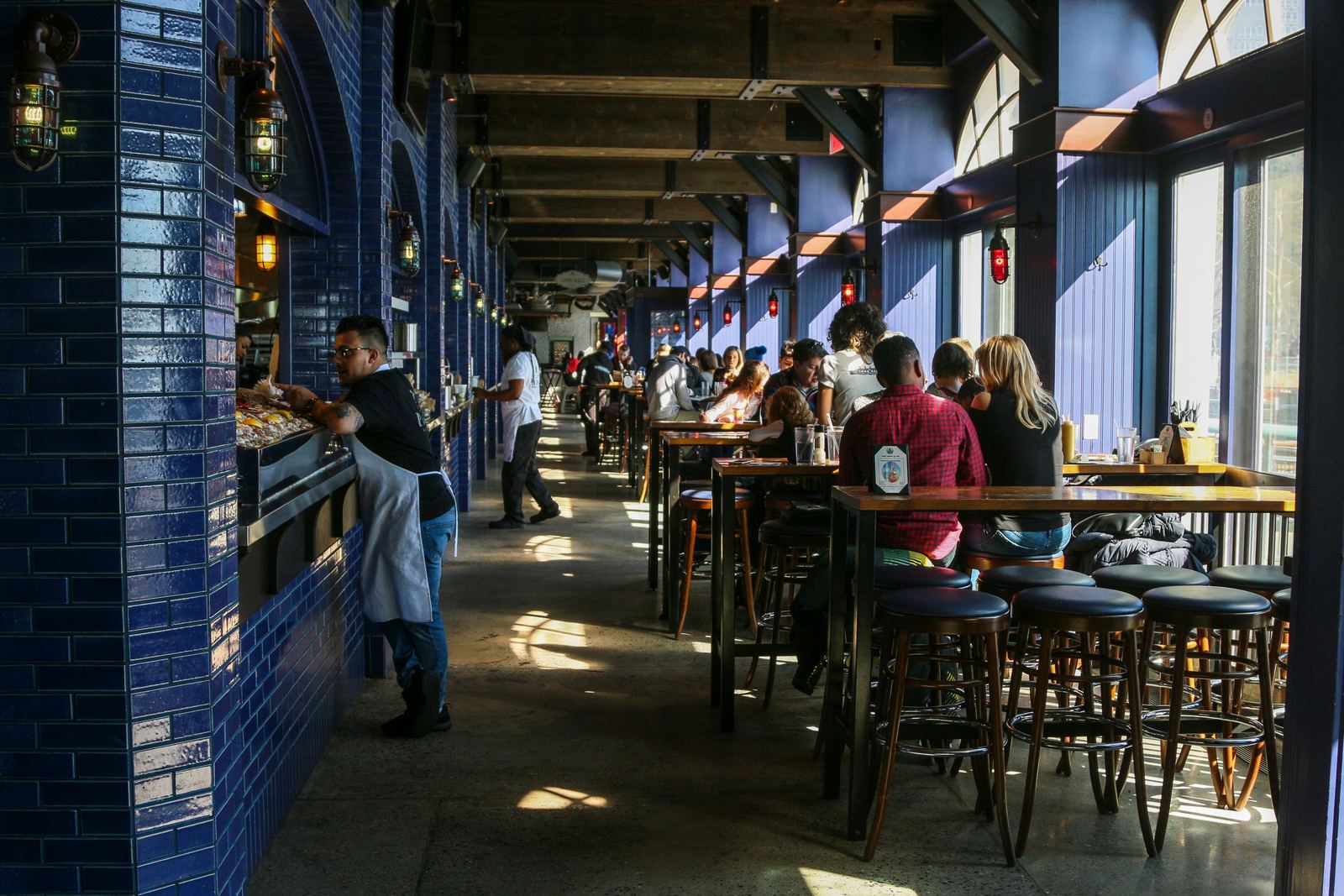 A busy restaurant dining room full of customers enjoying their meals
