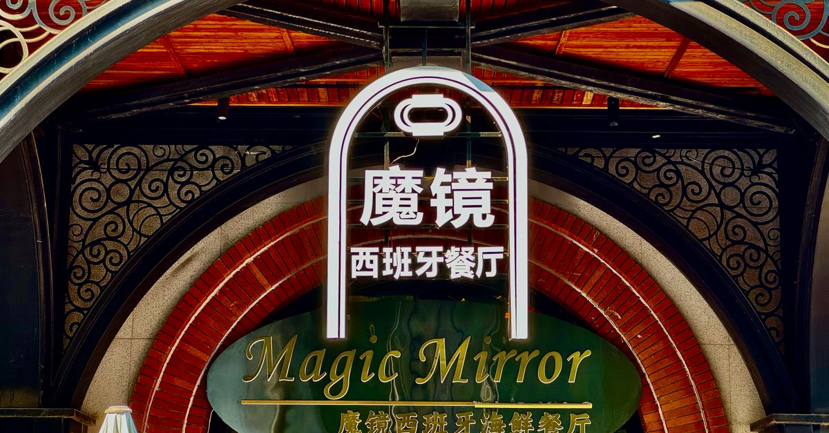 A restaurant storefront entrance with illuminated signage in the evening